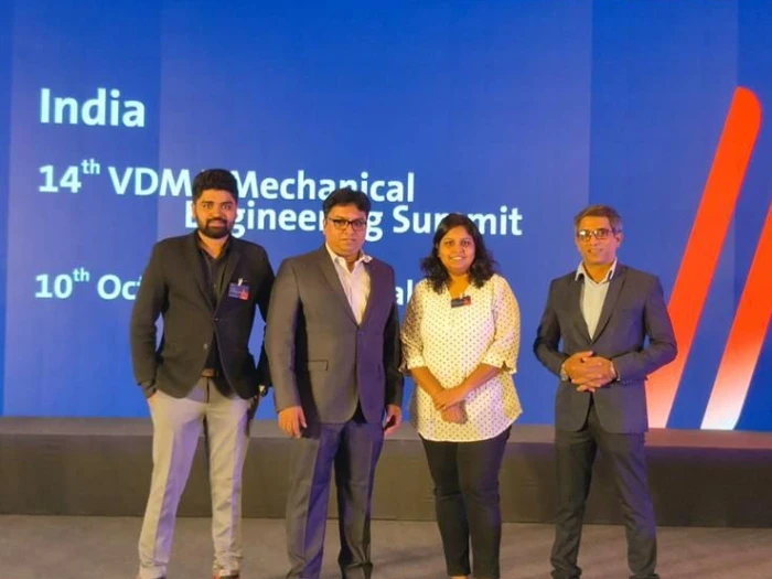 Four attendees in front of the VDMA Mechanical Engineering Summit stage backdrop.